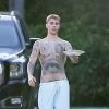 Justin Bieber sort de sa maison torse nu et pieds nus pour apporter une assiette de nourriture à son agent de sécurité à Beverly Hills le 4 octobre 2019.
