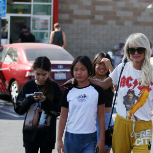 Laeticia Hallyday en jogging jaune, tee-shirt AC/DC et baskets pour déjeuner chez "In And Out Burger" avec ses filles Jade et Joy, son amie Hortense d'Estève et ses filles Romy et Nina avant d'aller les déposer à l'aéroport LAX de Los Angeles. Le 2 novembre 2019.