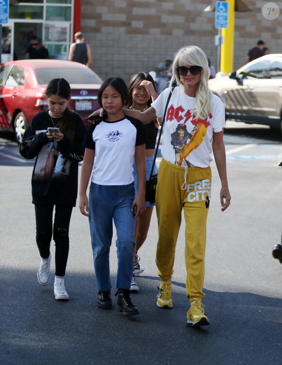 Laeticia Hallyday en jogging jaune, tee-shirt AC/DC et baskets pour déjeuner chez "In And Out Burger" avec ses filles Jade et Joy, son amie Hortense d'Estève et ses filles Romy et Nina avant d'aller les déposer à l'aéroport LAX de Los Angeles. Le 2 novembre 2019.