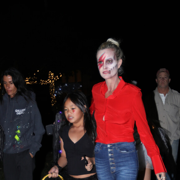 Laeticia Hallyday fait la chasse aux bonbons en famille dans le quartier résidentiel de Pacific Palisades à Los Angeles, le 31 Octobre 2019. Maquillée comme David Bowie, elle accompagne sa fille Joy (en ange noir) avec son amie Hortense d'Estève déguisée en Harley Queen avec sa fille cadette (en ange blanc) et Maryline Issartier.