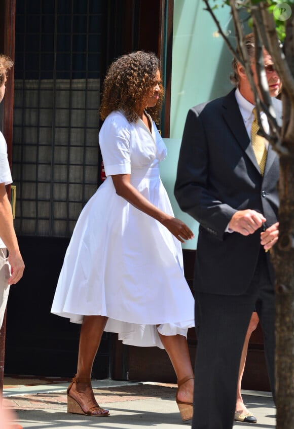 Michelle Obama porte une robe blanche à la sortie d'un immeuble à New York, le 25 juillet 2019