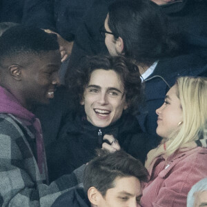 Stéphane Bak, Timothée Chalamet, Florence Pugh dans les tribunes lors du match de Champions League "PSG - Galatasaray (5-0)" au Parc des Princes à Paris, le 11 décembre 2019. © Cyril Moreau/Bestimage