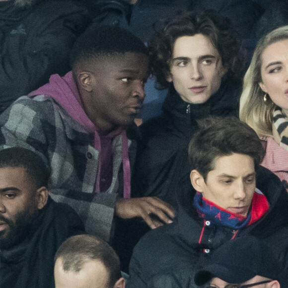 Stéphane Bak, Timothée Chalamet, Florence Pugh dans les tribunes lors du match de Champions League "PSG - Galatasaray (5-0)" au Parc des Princes à Paris, le 11 décembre 2019. © Cyril Moreau/Bestimage