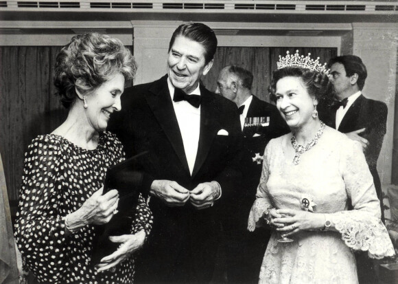 La reine Elisabeth II d'Angleterre avec le président des Etats-Unis Ronald Reagan et sa femme Nancy à une réception. Le 1er janvier 1985