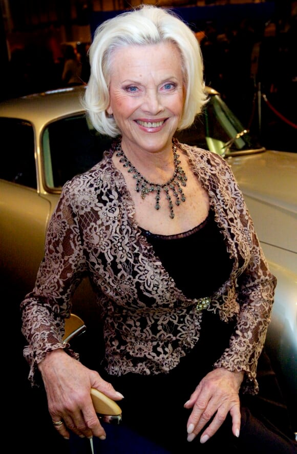 Honor Blackman pose devant ne Aston Martin DB5 au Classic Motor Show, à Birmingham en 2005.