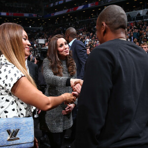 Kate Middleton, la duchesse de Cambridge, enceinte, rencontre la chanteuse Beyonce et son mari Jay-Z lors du match de basket-ball entre les Cleveland Cavaliers et les Brooklyn Nets à New York, le 8 décembre 2014.