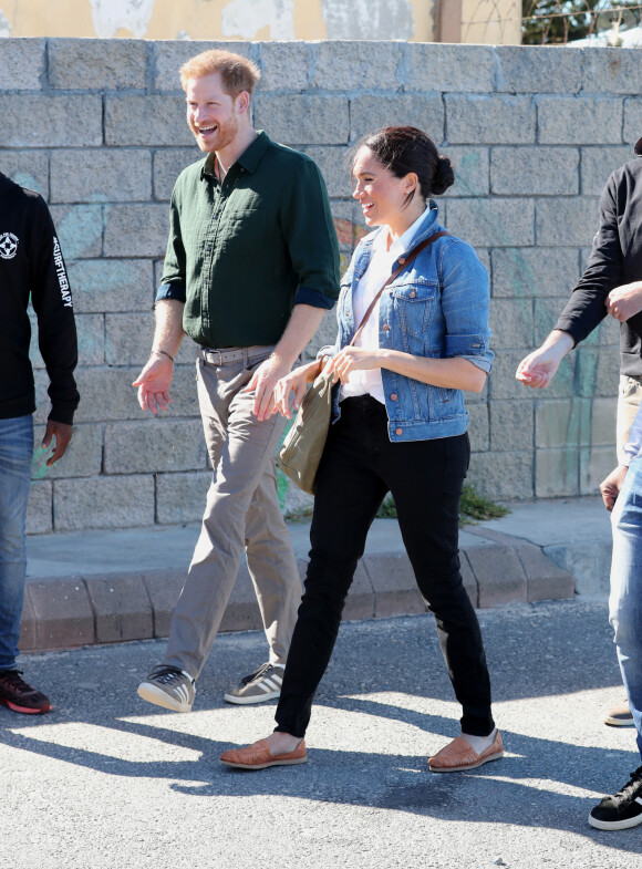 Le prince Harry, duc de Sussex, et Meghan Markle, duchesse de Sussex rencontrent les membres de "Waves for Change" un organisme de bienfaisance qui travaille avec les surfeurs locaux sur la plage de Monwabisi au Cap lors de leur 2ème journée en Afrique du Sud, le 24 septembre 2019.