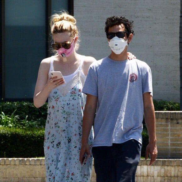 Exclusif - Elle Fanning et son compagnon Max Minghella font des selfies avec leurs masques lors d'une balade à Los Angeles, le 12 mai 2020.