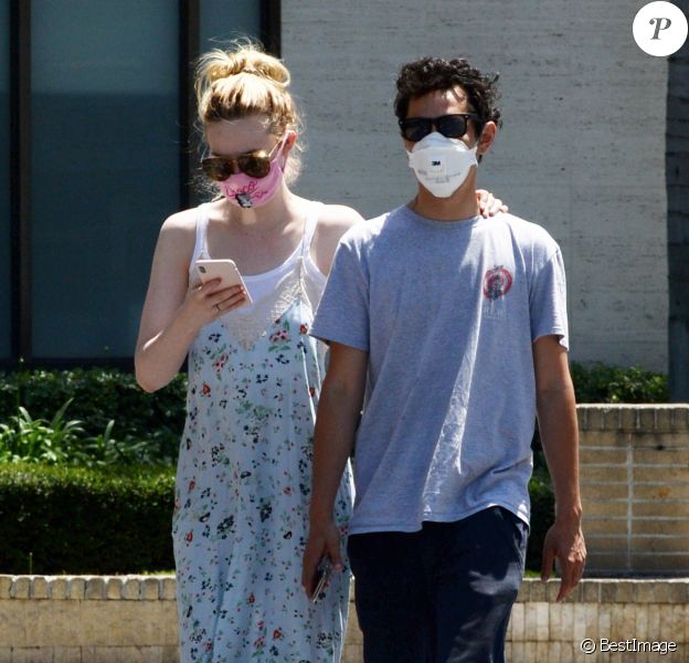 Exclusif - Elle Fanning et son compagnon Max Minghella font des selfies avec leurs masques lors d'une balade à Los Angeles, le 12 mai 2020.