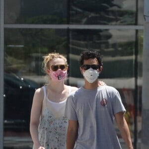 Exclusif - Elle Fanning et son compagnon Max Minghella font des selfies avec leurs masques lors d'une balade à Los Angeles, le 12 mai 2020.