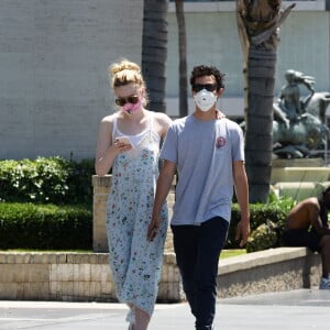 Exclusif - Elle Fanning et son compagnon Max Minghella font des selfies avec leurs masques lors d'une balade à Los Angeles, le 12 mai 2020.