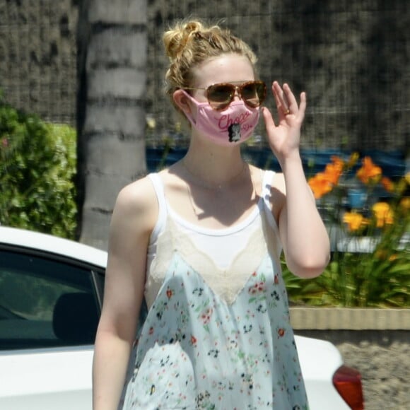 Exclusif - Elle Fanning et son compagnon Max Minghella font des selfies avec leurs masques lors d'une balade à Los Angeles, le 12 mai 2020.