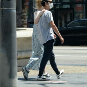 Exclusif - Elle Fanning et son compagnon Max Minghella font des selfies avec leurs masques lors d'une balade à Los Angeles, le 12 mai 2020.