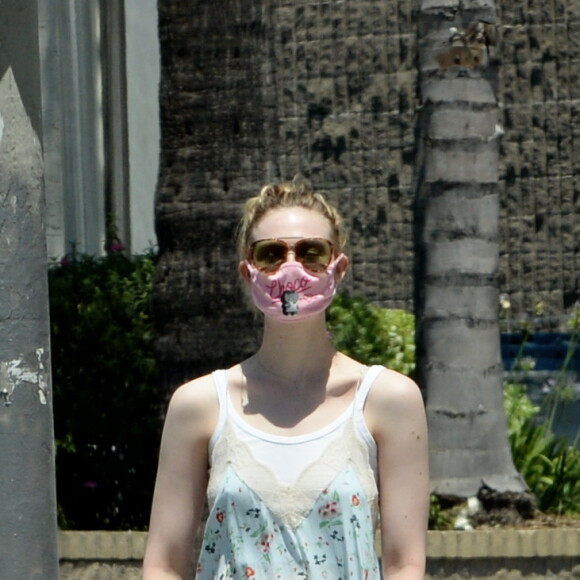 Exclusif - Elle Fanning et son compagnon Max Minghella font des selfies avec leurs masques lors d'une balade à Los Angeles, le 12 mai 2020.