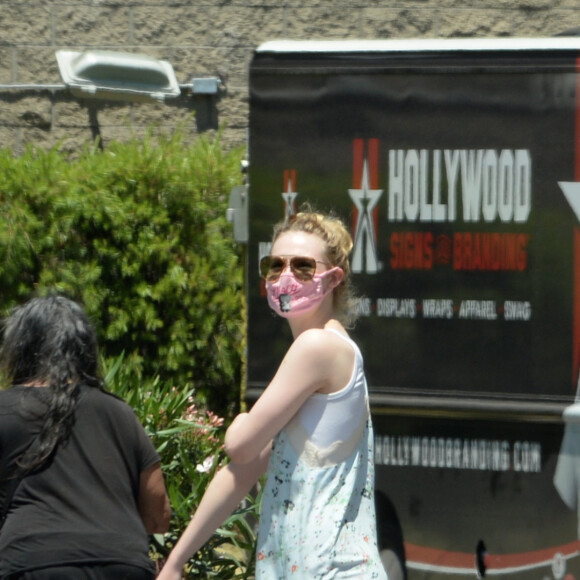 Exclusif - Elle Fanning et son compagnon Max Minghella font des selfies avec leurs masques lors d'une balade à Los Angeles, le 12 mai 2020.