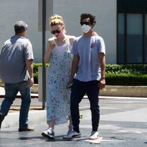 Exclusif - Elle Fanning et son compagnon Max Minghella font des selfies avec leurs masques lors d'une balade à Los Angeles, le 12 mai 2020.