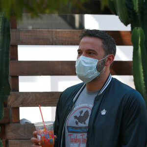 Exclusif - Ben Affleck et Ana de Armas, équipés de masques, se promènent avec le chien de l'actrice tandis que Ben Affleck se désaltère avec une boisson fraîche à Los Angeles, le 14 mai 2020.