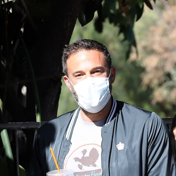 Exclusif - Ben Affleck et Ana de Armas, équipés de masques, se promènent avec le chien de l'actrice tandis que Ben Affleck se désaltère avec une boisson fraîche à Los Angeles, le 14 mai 2020.