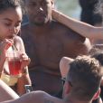 Leigh Anne Pinnock et son compagnon Andre Grey sont en vacances à Mykonos, le 8 juin 2019. La chanteuse porte un bikini jaune et mange des chips après avoir passé l'après midi à la plage.