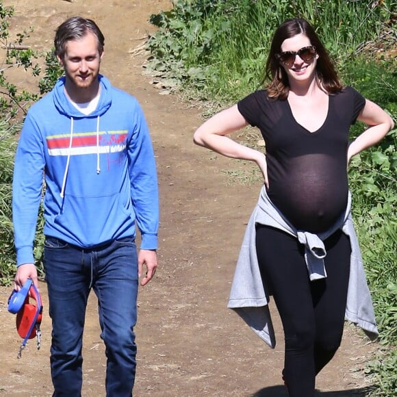 Anne Hathaway, enceinte, se promène avec son mari Adam Shulman et ses chiens à Los Angeles le 12 Mars 2016.