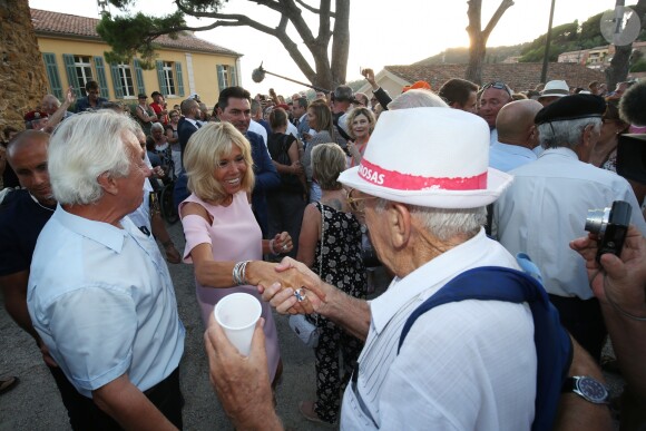 Brigitte Macron danse avec un vacancier - Le Président de la République Emmanuel Macron et sa femme la Première Dame Brigitte Macron (Trogneux) ont participé à un pot de l'amitié suivi d'un bain de foule sur la place centrale du village de Bormes-les-Mimosas, le 17 août 2018. © Luc Boutria / Nice Matin / Bestimage