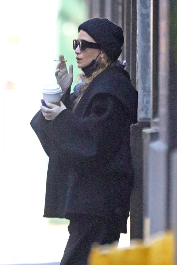 Exclusif - Ashley Olsen, munie de gants, fait une pause cigarette et café devant son bureau à New York, le 20 mai 2020. Pendant ce temps, sa soeur jumelle Mary-Kate est en pleine procédure de divorce.