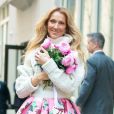 Celine Dion rayonnante et très souriante dans un ensemble pull écru et jupe bouffante fleurie salue ses fans à la sortie de son hôtel à New York, le 8 mars 2020   