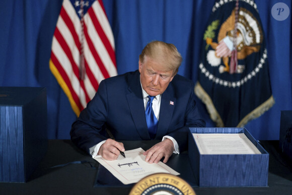 Le président américain Donald Trump, signe la loi de crédits consolidée 2021 dans le salon de thé de Mar-a-Lago à Palm Beach, en Floride.