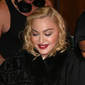 Madonna porte un manteau Versace et marche à l'aide d'une canne à la sortie du London Palladium à Londres.