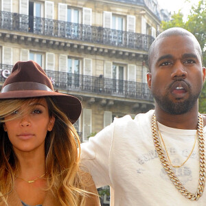 Kim Kardashian, avec sa nouvelle couleur de cheveux (blonde), et Kanye West devant leur hotel a Paris, le 28 septembre 2013.