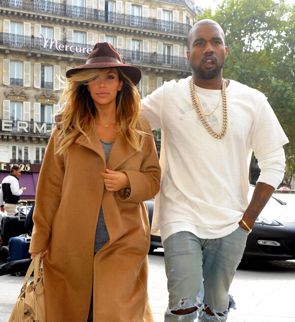 Kim Kardashian, avec sa nouvelle couleur de cheveux (blonde), et Kanye West devant leur hotel a Paris, le 28 septembre 2013.