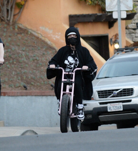 Exclusif - Billie Eilish fait du vélo électrique avec son frère Finneas O'Connell à Los Angeles, le 21 décembre 2020. Sur son vélo rose, la chanteuse de 19 ans était dissimulée derrière son masque de protection contre le coronavirus (Covid-19) et son hoodie.