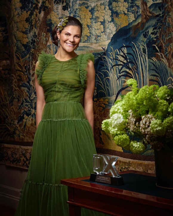 Au palais Haga, la princesse Victoria (en robe H&M Conscious) pose avec son prix de la personnalité hétéro de l'année 2021, remis par le magazine scandinave QX.