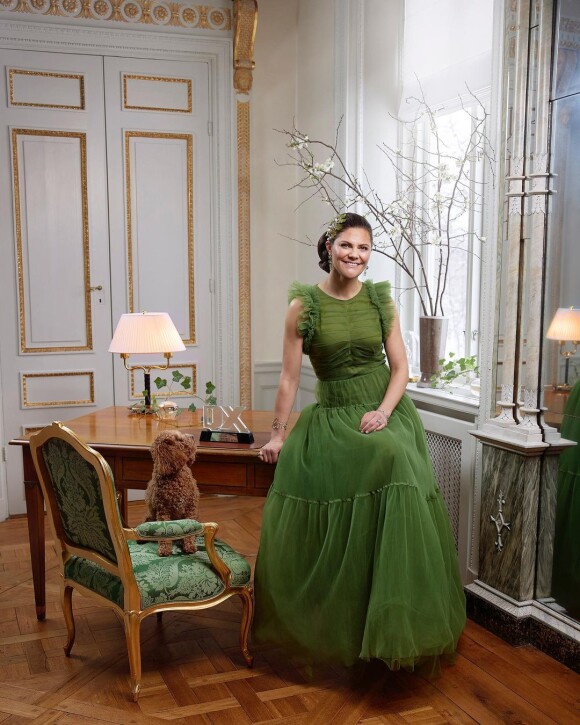 Au palais Haga, la princesse Victoria (en robe H&M Conscious) pose avec son prix de la personnalité hétéro de l'année 2021, remis par le magazine scandinave QX.