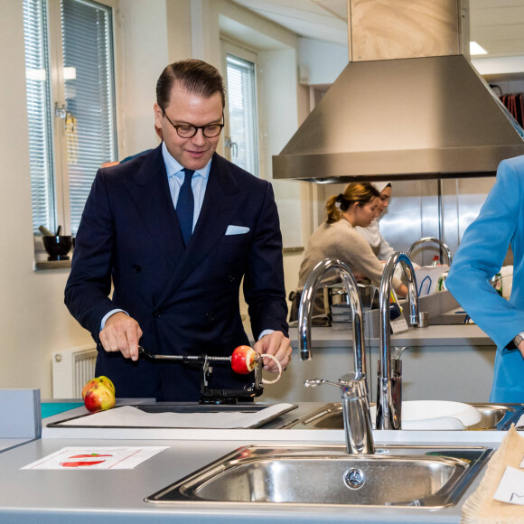 La princesse Victoria et le prince Daniel de Suède visitent l'école Rinman à Eskilstuna, le 22 octobre 2020. Le couple princier s'est amusé à peler des pommes . Cette visite s'inscrit dans une campagne d'information sur l'épidémie de coronavirus (Covid-19).