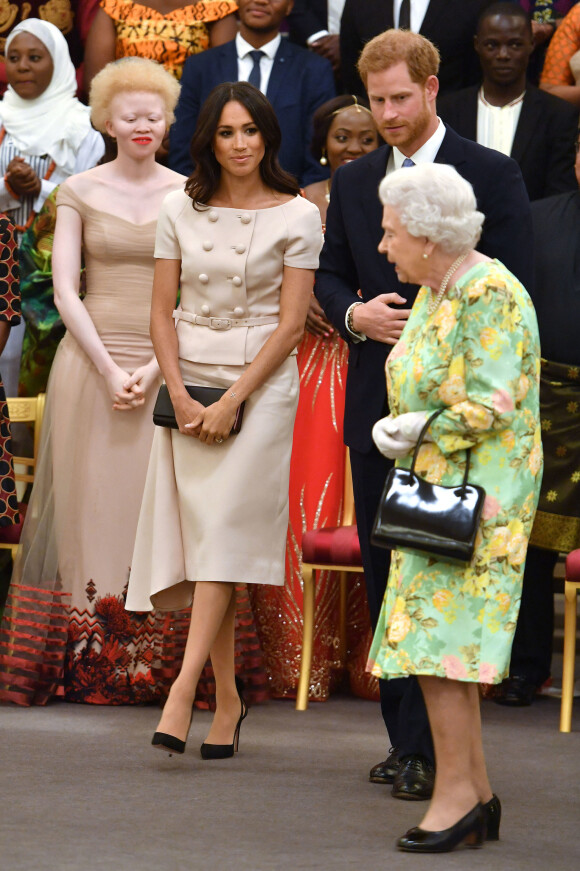Le prince Harry, duc de Sussex, Meghan Markle, duchesse de Sussex, et la reine Elizabeth II d'Angleterre à la cérémonie "Queen's Young Leaders Awards" au palais de Buckingham à Londres le 26 juin 2018.