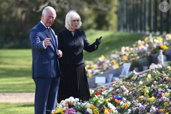 Le prince Charles, prince de Galles et la duchesse de Cornouailles, Camila Parker-Bowles, passent en revue les hommages au prince Philip dans les jardins de Marlborough House à Londres le 15 avril 2021.