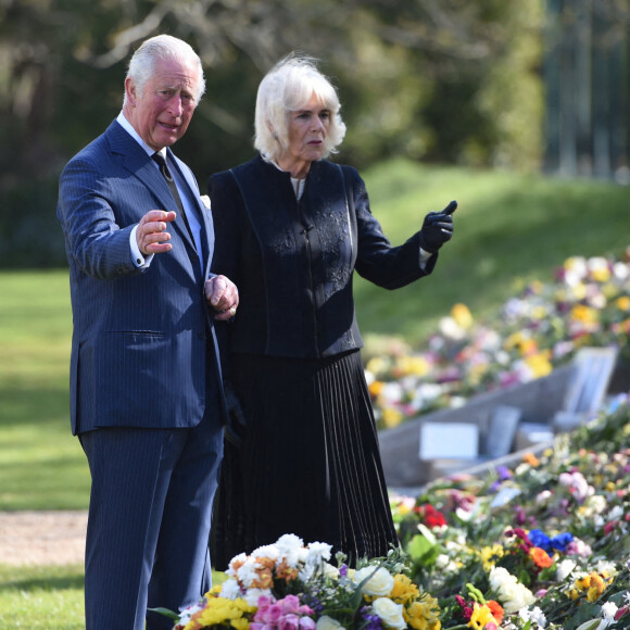Le prince Charles, prince de Galles et la duchesse de Cornouailles, Camila Parker-Bowles, passent en revue les hommages au prince Philip dans les jardins de Marlborough House à Londres le 15 avril 2021.
