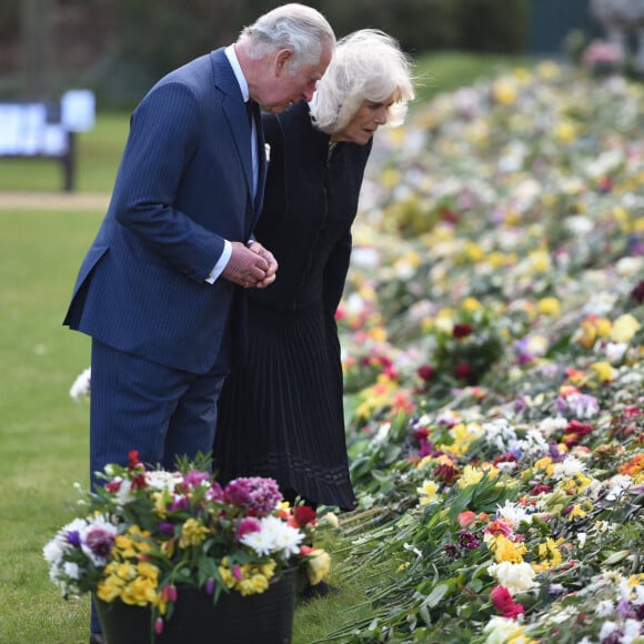 Le prince Charles, prince de Galles et la duchesse de Cornouailles Camila Parker-Bowles passent en revue les hommages au prince Philip dans les jardins de Marlborough House à Londres le 15 avril 2021.