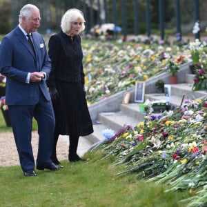 Le prince Charles, prince de Galles et la duchesse de Cornouailles Camila Parker-Bowles passent en revue les hommages au prince Philip dans les jardins de Marlborough House à Londres le 15 avril 2021.