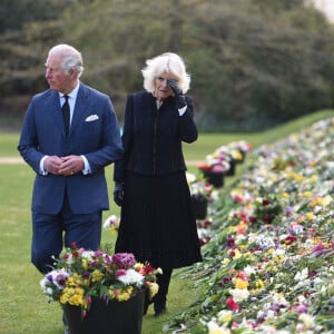 Le prince Charles, prince de Galles et la duchesse de Cornouailles Camila Parker-Bowles passent en revue les hommages au prince Philip dans les jardins de Marlborough House à Londres.