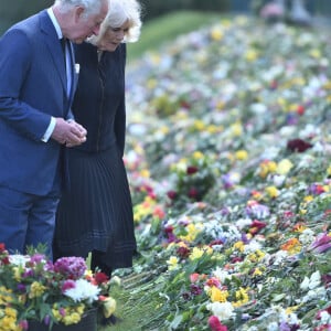 Le prince Charles, prince de Galles et la duchesse de Cornouailles Camila Parker-Bowles passent en revue les hommages au prince Philip dans les jardins de Marlborough House à Londres le 15 avril 2021.