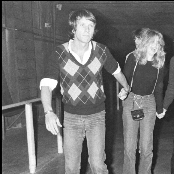 Archives - Yves Rénier, Goldie Hawn et Steven Spielberg sur des patins à roulettes lors d'une soirée à la main jaune.