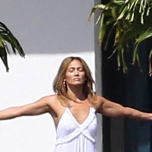 Jennifer Lopez fait des étirements pieds nus devant la maison qu'elle partage avec Ben.Affleck à Miami le 25 mai 2021.