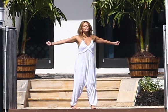 Jennifer Lopez fait des étirements pieds nus devant la maison qu'elle partage avec Ben.Affleck à Miami le 25 mai 2021.