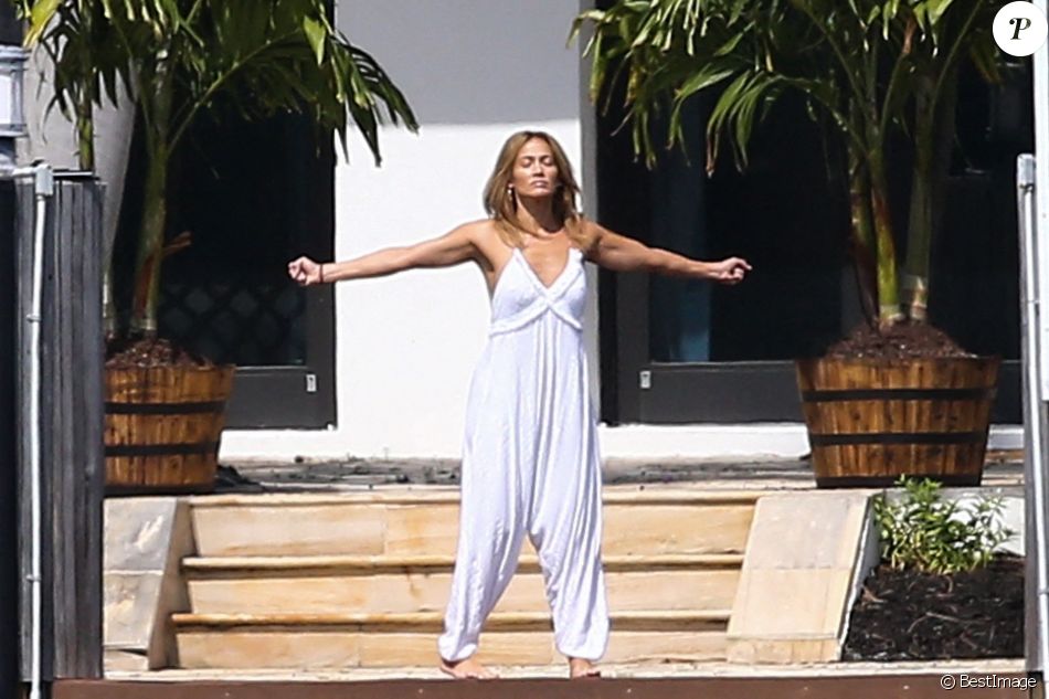 Jennifer Lopez fait des étirements pieds nus devant la maison qu'elle partage avec Ben.Affleck à Miami le 25 mai 2021.
