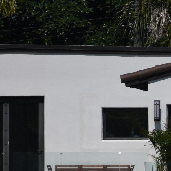 Pendant que Ben Affleck fume une cigarette sur le balcon de leur maison, Jennifer Lopez sort discuter avec son fils Maximilian (Max) à Miami le 24 mai 2021. 