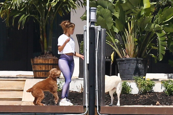 Pendant que Ben Affleck fume une cigarette sur le balcon de leur maison, Jennifer Lopez sort discuter avec son fils Maximilian (Max) à Miami le 24 mai 2021.