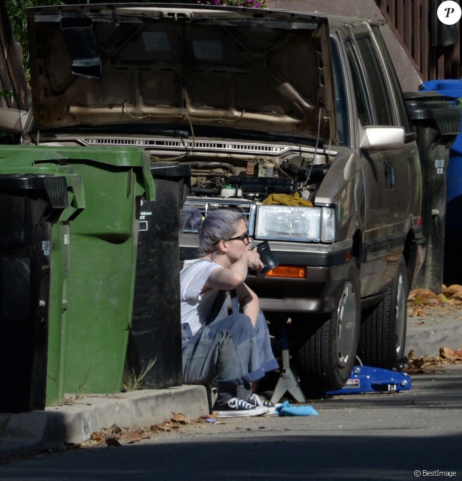 Kelly Osbourne aide son compagnon Erik Bragg à réparer sa voiture sur un trottoir de Los Angeles le 11 avril 2021.