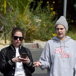 Exclusif - Cara Delevingne et sa femme Ashley Benson font un peu d'exercice dans leur quartier de Los Angeles le 20 mars 2020. Cara portait un pantalon de jogging noir, un sweat à capuche gris, un bonnet gris et des baskets Golden Goose. Ashley arborait un pantalon rouge, des baskets Converse et une veste universitaire noire.